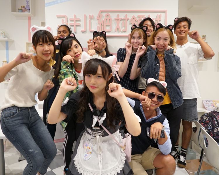 A maid and guests at Maid Cafe